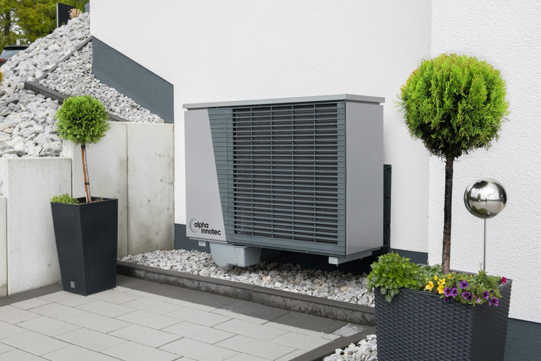 Residential outdoor heat pump HVAC unit installed beside a modern home